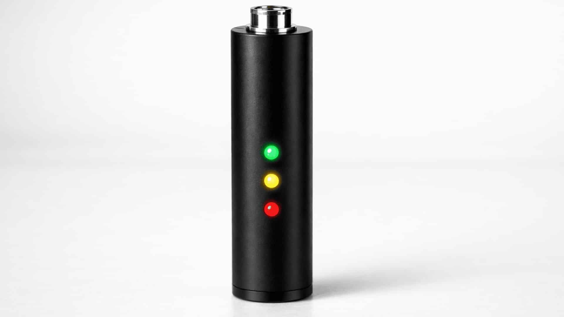 close-up of a sleek black 510-thread vape battery with green, yellow, and red LED lights indicating voltage levels