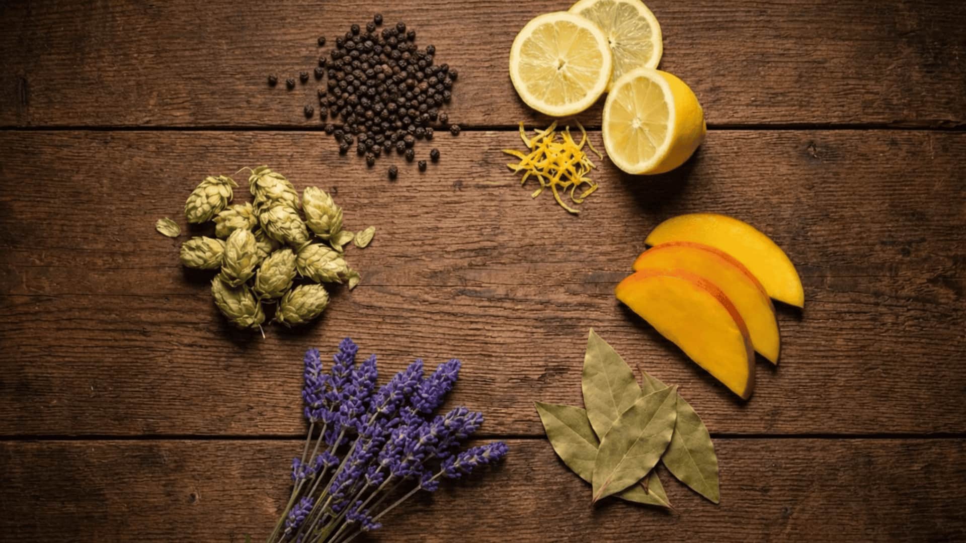 jealousy strain terpene ingredients flat lay with black pepper lemon hops lavender mango and bay leaves on wood