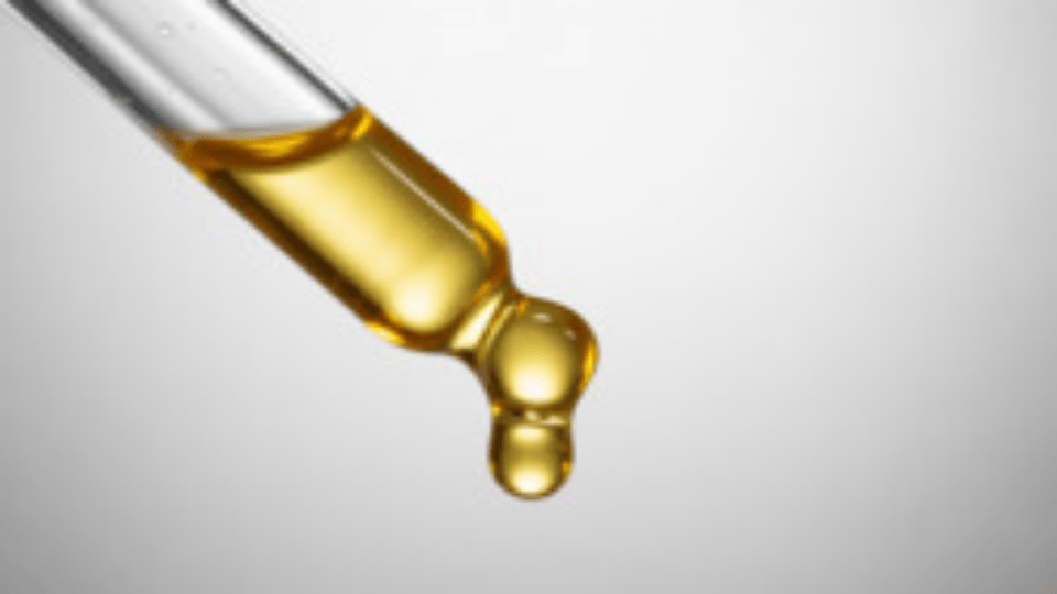 cbd oil dropper releasing golden oil drop against a clean background showing texture and clarity