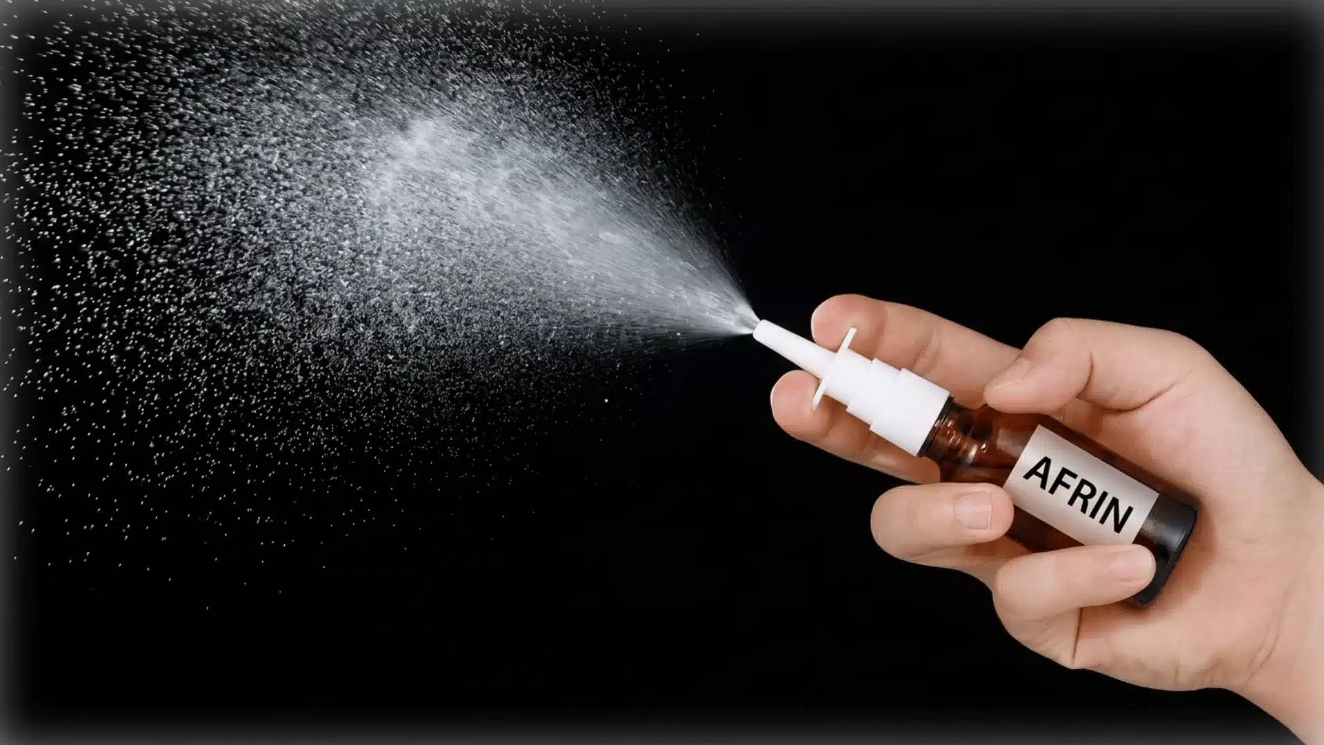 close-up photograph of a hand holding a brown glass medicine nose spray bottle with written afrin on it