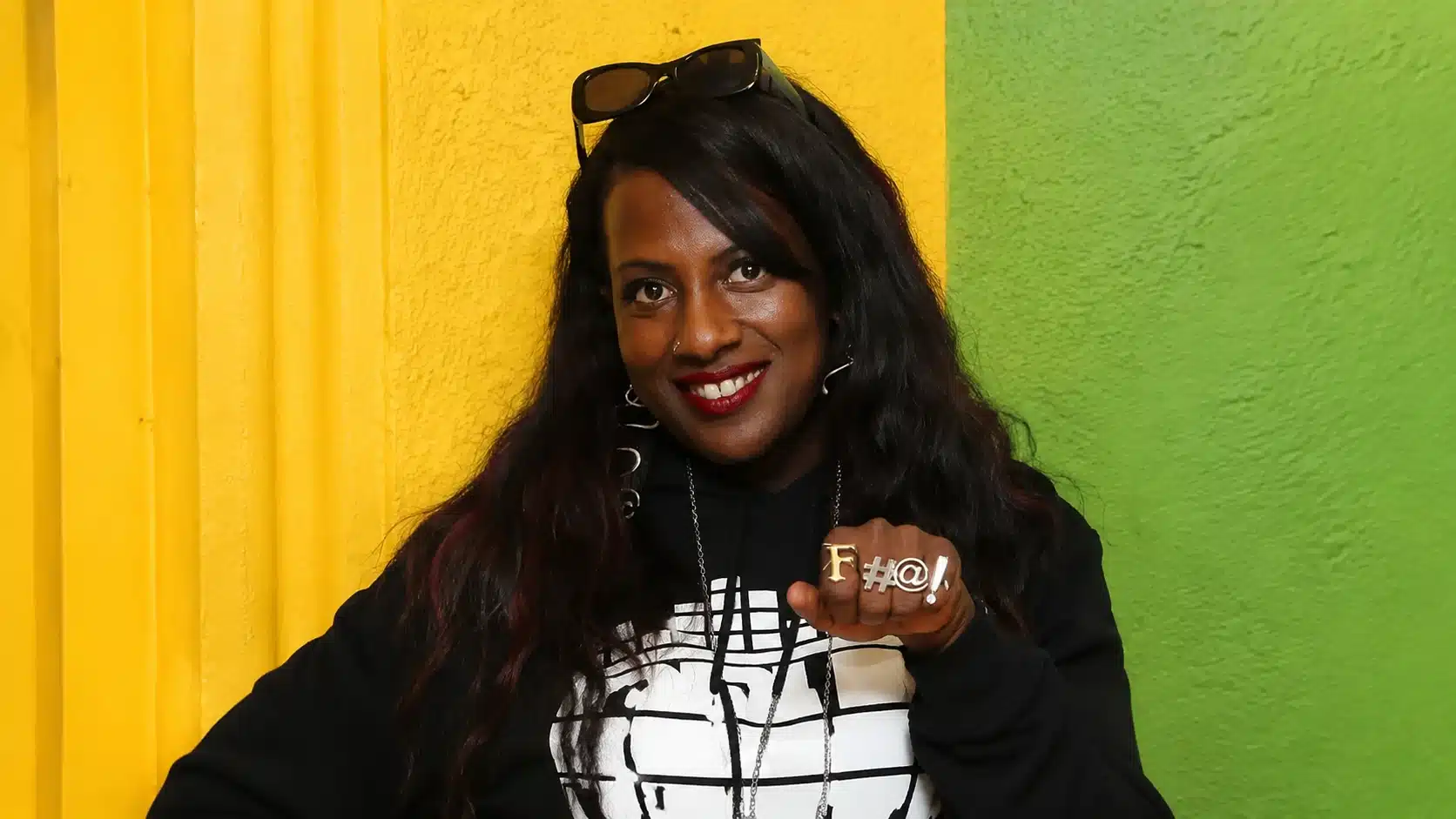 a black woman with red lipstick wearing a hoodie and bold 