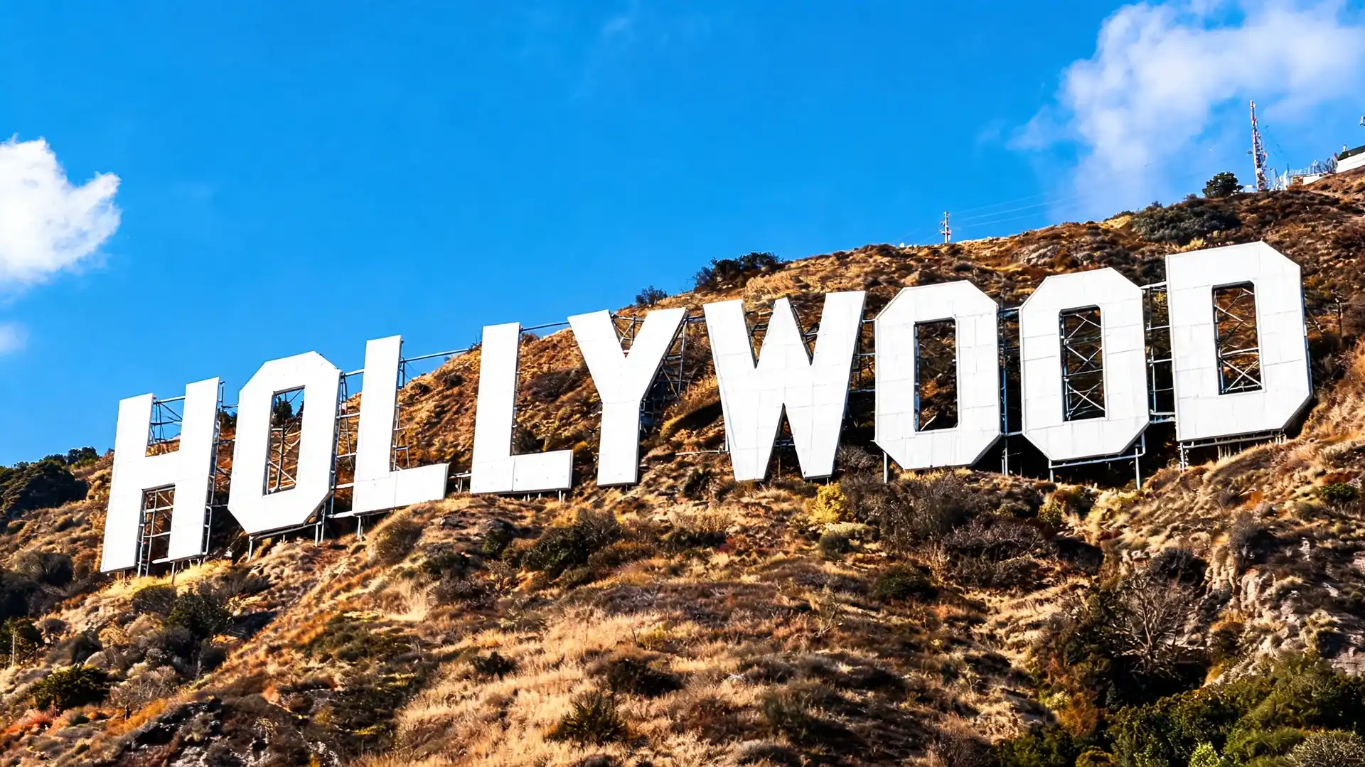 close-up view of the hollywood sign on hillside beneath partly cloudy blue skies in los angeles, california landscape