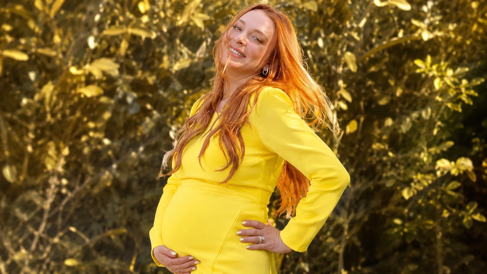 outdoor portrait teling what happened to lindsay lohan showing her smiling in bright yellow dress with long red hair