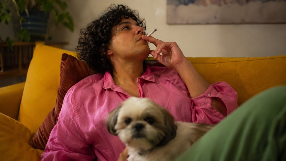 Person relaxing on a couch smoking a Peanut Butter Breath joint