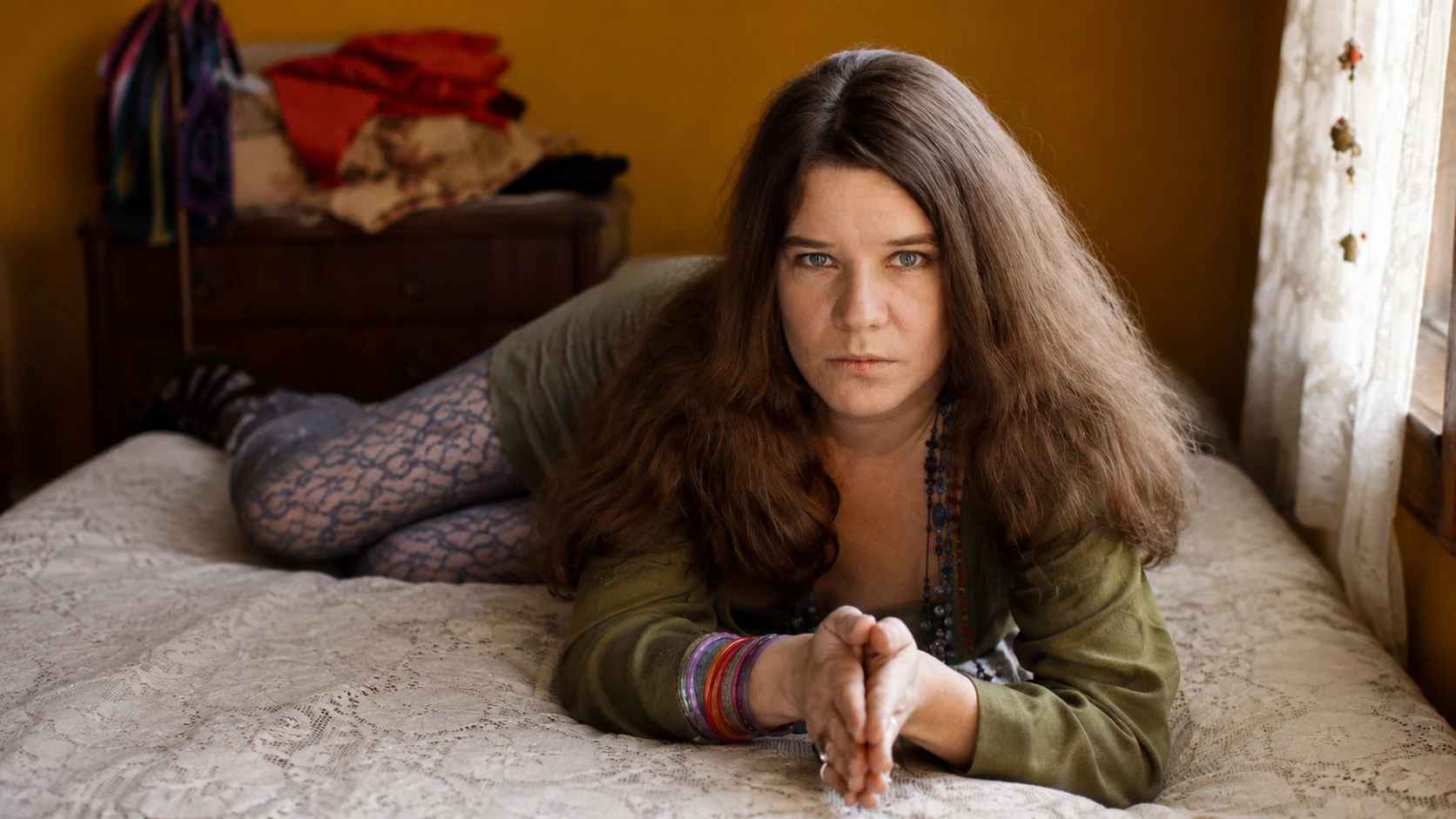 portrait for an article on female singers who died of an overdose, showing a solemn woman in a vintage bedroom