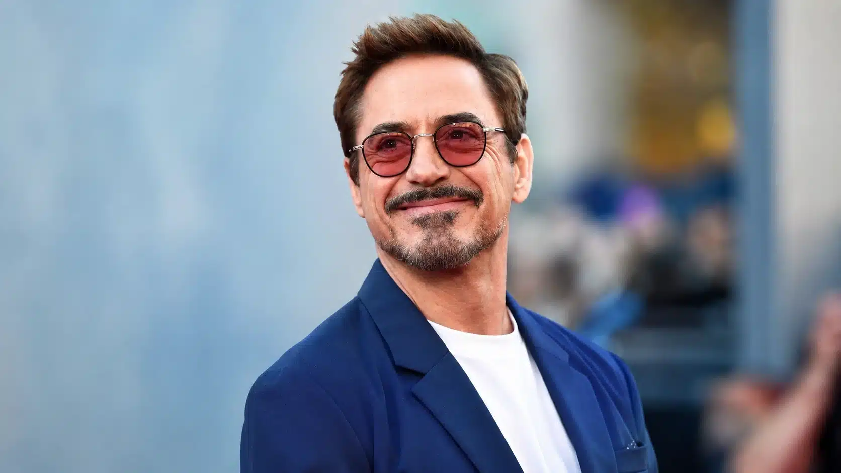 robert downey jr. smiling in blazer, showing recovery and strength after robert downey jr addiction struggles