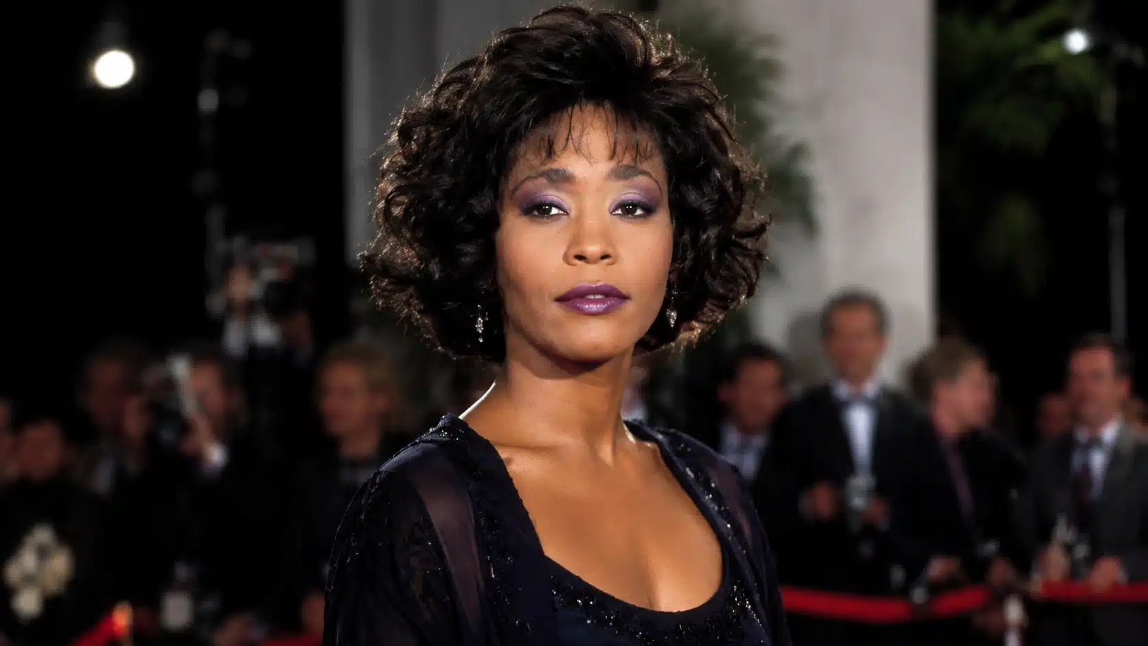 whitney houston on the red carpet, wearing purple eyeshadow and lipstick, with her signature curly hair, with elegance