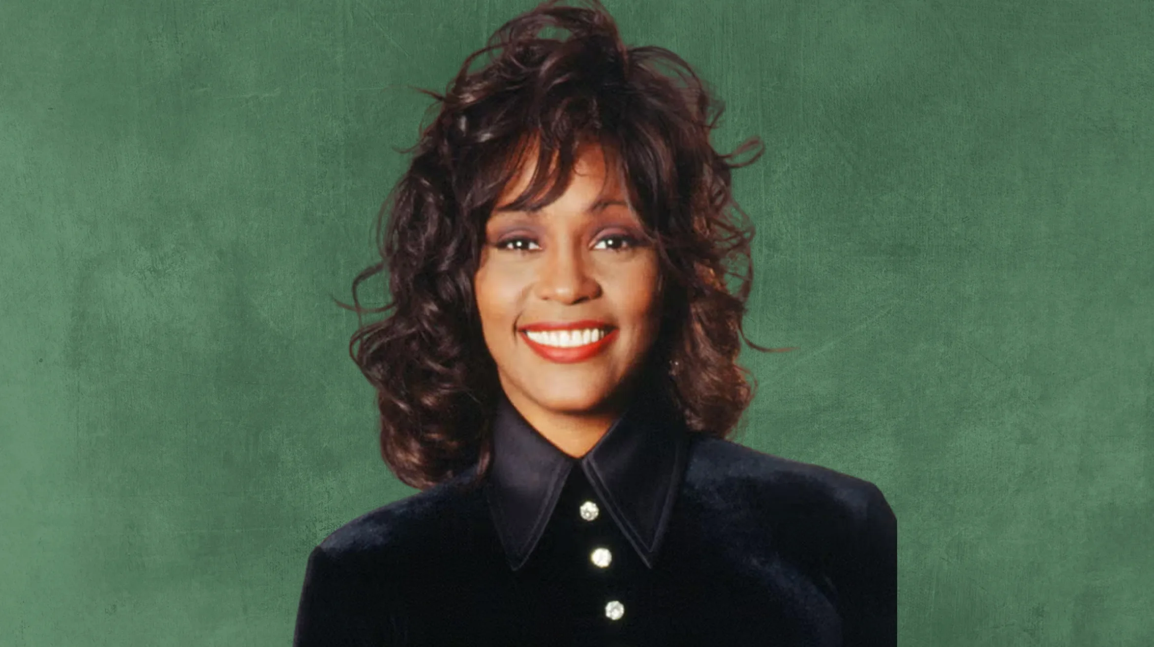 woman with curly hair and red lipstick, wearing a black velvet shirt with a collared neck, against a green background