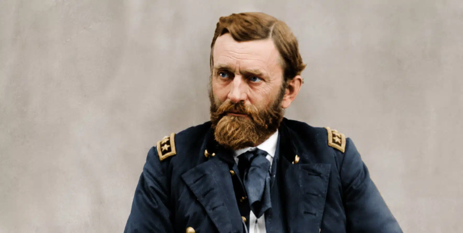 colorized portrait of a bearded civil war officer in dark uniform, seated against a soft neutral studio backdrop