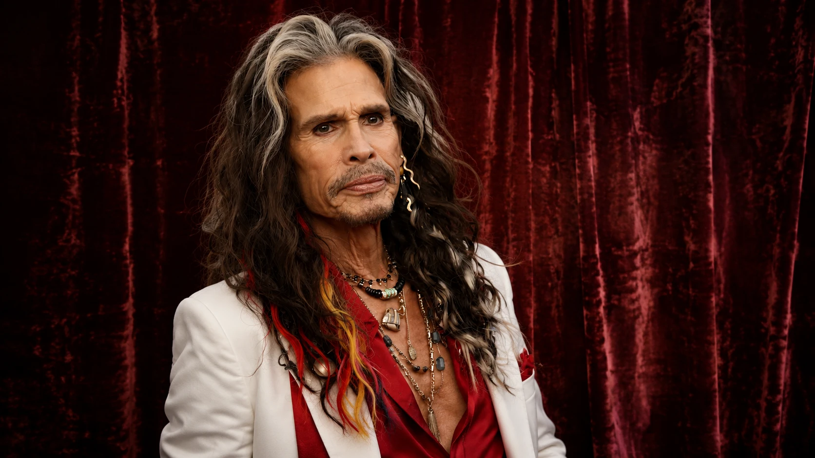 steven tyler portrait in white and red outfit against red velvet backdrop, featuring studio lighting and rockstar style
